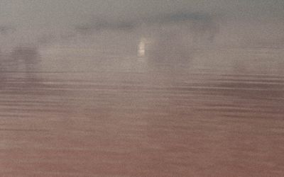 A calm, still body of water reflecting the sky, evoking a sense of tranquility.