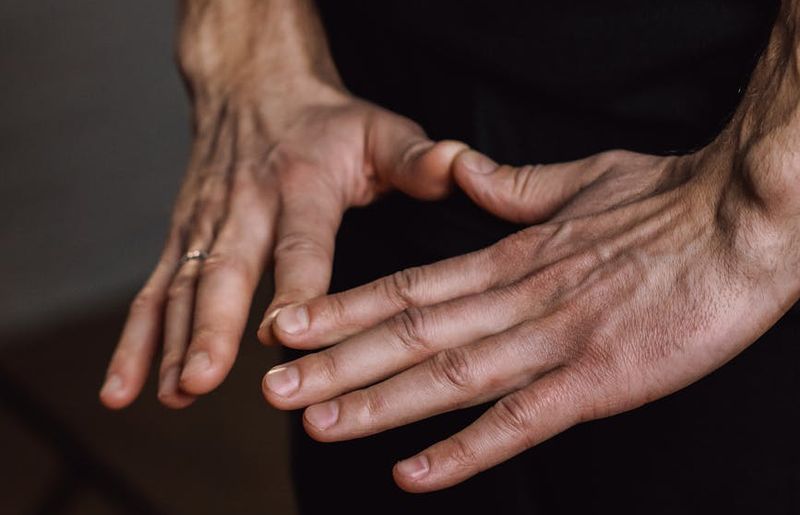 Close-up shot of a person's hands in a precise yoga mudra, fingers touching.